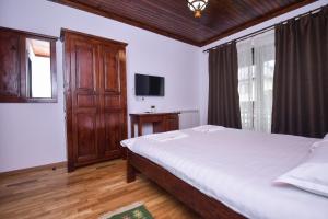 una camera con un grande letto e una TV di Piatra Soimului a Vişeu de Sus