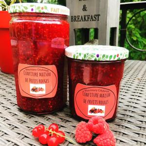 two jars of raspberry jam on a table with raspberries at Maunoury Citybreak in Chartres