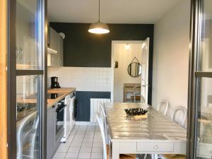 a kitchen with a table and a counter top at L'Octroi in Chartres