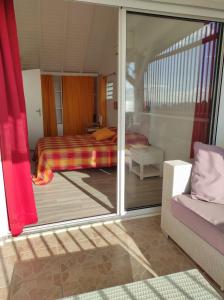 1 dormitorio con 1 cama y puerta corredera de cristal en villa Azur A, en Bouillante