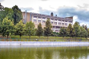 duży budynek obok zbiornika wodnego w obiekcie Orly Park-Hotel w Kijowie