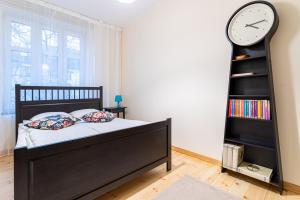 ソポトにあるVictus Apartamenty, Apartament Etnaのベッドルーム1室(ベッド1台、壁掛け時計付)