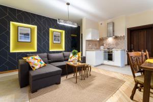 uma sala de estar com um sofá, uma mesa e uma cozinha em Victus Apartamenty, Apartament Etna em Sopot
