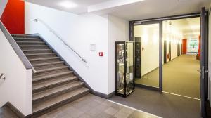 eine Treppe in einem Gebäude mit einem Glasaufzug in der Unterkunft Hotel Im Schulhaus in Lorch am Rhein