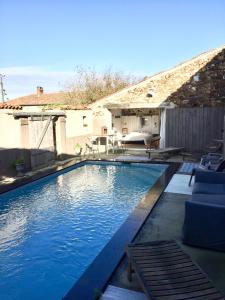 a swimming pool in a backyard with a house at Gites De L'Etang Des Noues in Cholet