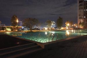 ein großer Swimmingpool in der Nacht mit Lichtern in der Unterkunft HB1611 Lake view studio unit,Hyve, Cyberjaya, Free WiFi, Netflix, Pool, Free Parking, 3039 in Cyberjaya