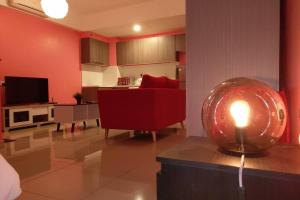 ein Wohnzimmer mit einer roten Couch und einer Kerze auf dem Tisch in der Unterkunft HB1611 Lake view studio unit,Hyve, Cyberjaya, Free WiFi, Netflix, Pool, Free Parking, 3039 in Cyberjaya