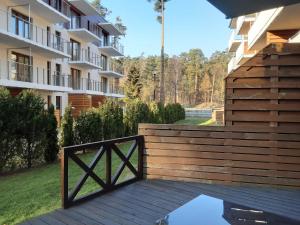 a wooden deck with a gate in front of a building at APARTAMENTY NADMORSKIE STEGNA BALTIC PARK in Stegna
