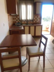 a kitchen with a wooden table and two chairs and a table at Antonia Apartments in Fira
