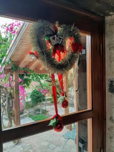 a christmas wreath is hanging on a window at Blue Cottage in Apsiou