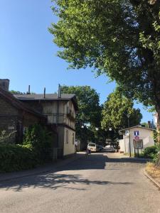 een lege straat met een gebouw en een boom bij Brezno Apartament in Gdańsk