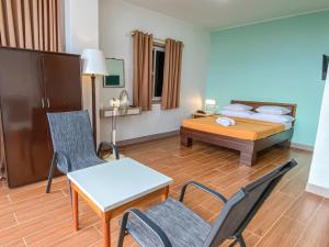 碧瑤的住宿－美羅松樹賓館，酒店客房带一张床、一张桌子和椅子
