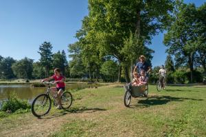 a group of children riding bikes with a man on a cart at Dôme Paradise by Home From Home in Dol-de-Bretagne