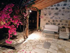 un patio con una silla y flores en una habitación en Blue Cottage, en Apsiou