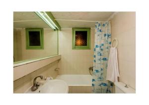 y baño con lavabo, bañera y espejo. en Elounda Collection Apartments, en Elounda
