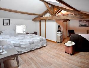 1 dormitorio con 1 cama grande en una habitación con suelo de madera en Logis de La Bénétière, en Treize-Vents