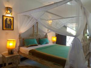 a bedroom with a bed with a canopy at Mvuvi Fishing Lodge in Watamu +111 photos