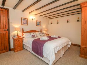 een slaapkamer met een groot bed in een kamer bij Stable Cottage in Colyton