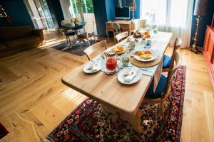 The Lion's Den BnB في ترييستي: طاولة خشبية عليها طعام في غرفة المعيشة