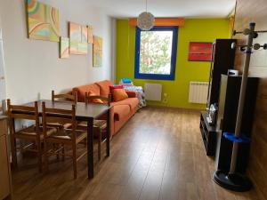 ein Wohnzimmer mit Sofa und Tisch in der Unterkunft Apartamentos San Isidro in León