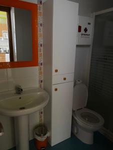 ein Badezimmer mit Waschbecken und Toilette in der Unterkunft Apartamentos San Isidro in León + 25 Fotos