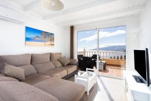 uma sala de estar com um sofá e uma televisão em Home2Book Amazing Sea Views, Terrace & Pool em Tabaiba