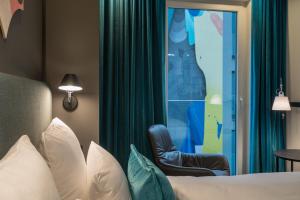 a living room filled with furniture and a window at Motel One Berlin-Alexanderplatz in Berlin