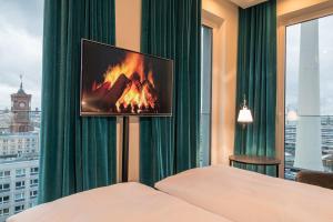 a hotel room with a fireplace and a tv on the wall at Motel One Berlin-Alexanderplatz in Berlin