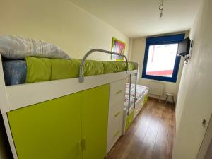 ein Schlafzimmer mit einem Etagenbett und einem Kinderbett in der Unterkunft Apartamentos San Isidro in León
