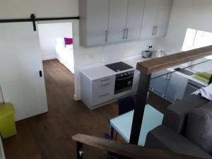 eine Küche mit weißen Schränken und ein Wohnzimmer in der Unterkunft Dream Cottage in Castletownbere