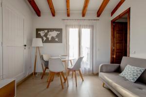 a living room with a couch and a table and chairs at Confraria Singular Suites in Palma de Mallorca