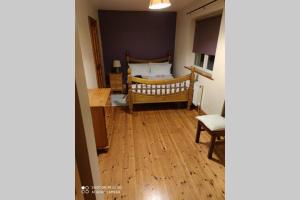 1 dormitorio con 1 cama y suelo de madera en Townhouse 3 Barrow Lane, en Bagenalstown