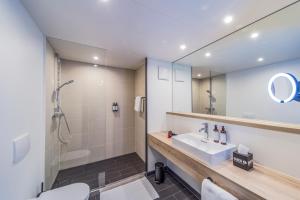a bathroom with a sink and a shower and a mirror at Black F House - Serviced Apartments in Freiburg im Breisgau +50 photos