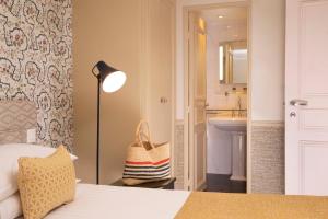 a room with a bed and a lamp at Hotel Relais Bosquet by Malone in Paris