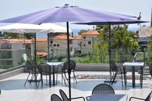 a patio with tables and chairs and umbrellas at 4- you Family in Metamorfosi