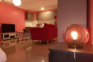 a living room with a red couch and a candle on a table at B17-15-Amazing Lake view studio unit, Hyve,Cyberjaya, Free WiFi, Free Parking, Netflix, Pool, 3044 in Cyberjaya