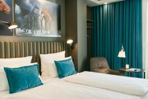 
a hotel room with two beds and two lamps at Motel One Berlin Ku'Damm in Berlin
