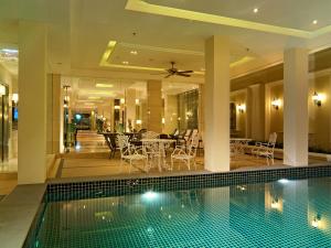 a house with a swimming pool and a dining room at Gulliver's Tavern Hotel in Bangkok