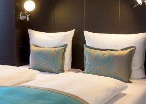 a bed with white sheets and pillows at Motel One Berlin-Potsdamer Platz in Berlin