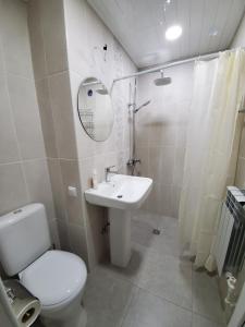 a white bathroom with a toilet and a sink at Central Guesthouse Gyumri in Gyumri