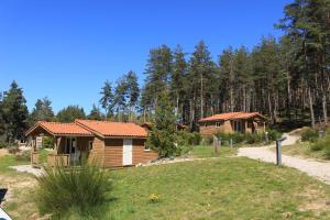 una baita di tronchi in un campo vicino a una foresta di Les Chalets du Haut-Forez a Usson-en-Forez