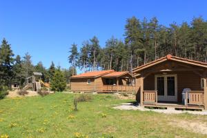 una cabaña de madera en un campo junto a un bosque en Les Chalets du Haut-Forez en Usson-en-Forez