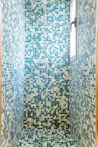 a bathroom with a shower with blue and green tiles at Confraria Singular Suites in Palma de Mallorca