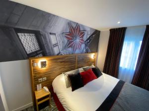 een hotelkamer met een bed en een muur bij Logis - Le Christina in Bourges