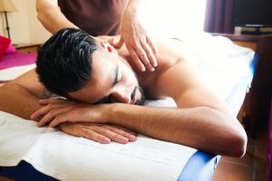 a man getting a back massage on a bed at Hotel Albaida Nature in Mazagón