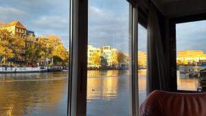 a view of a river from a window at Rembrandt Square Boat in Amsterdam