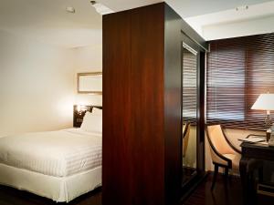 a hotel room with a bed and a desk and a desk sidx sidx sidx sidx at Gulliver's Tavern Hotel in Bangkok +16 photos