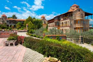 a large building with a garden in front of it at Hotel Strass in Paralia Katerinis