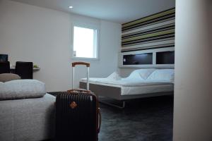 Un pat sau paturi într-o cameră la My Hotel Fribourg
