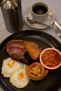 a plate of food with eggs, sausage, and bacon at Milford Hall Hotel & Spa in Salisbury